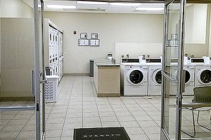 Castelar laundry room with several washers, dryers, and chairs